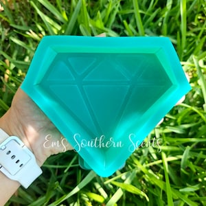 May include: A teal blue diamond-shaped silicone mold. The mold has a raised diamond pattern inside.
