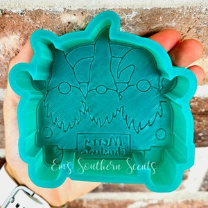 May include: A teal blue silicone mold shaped like a Christmas car with two gnomes in the front. The car has a license plate that reads "Christmas Merry".