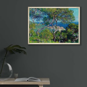 May include: A painting of a coastal scene with a view of a town from a hillside. The painting is done in a style reminiscent of Impressionism, with visible brushstrokes and a focus on light and color. The scene is dominated by a bright blue sky and a turquoise sea, with lush green trees in the foreground.