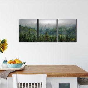 May include: A set of three framed prints depicting a misty forest scene with lush green trees. The prints are arranged in a horizontal row and feature a muted color palette.