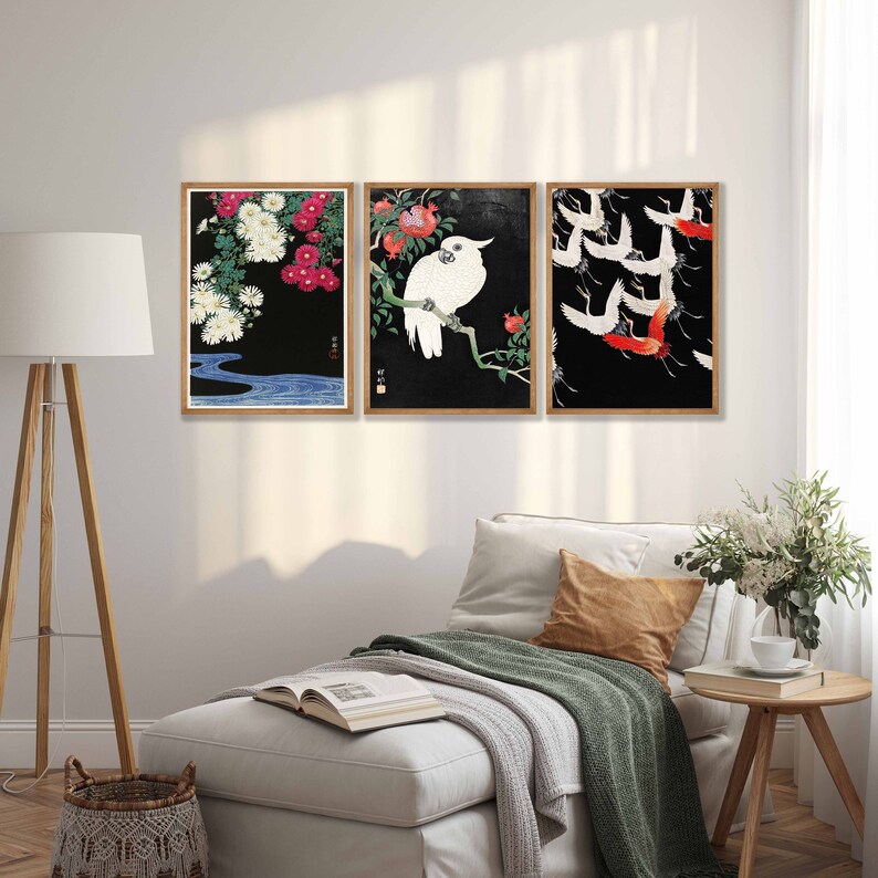 K&ouml;nnte beinhalten: Drei gerahmte Drucke mit schwarzen Hintergr&uuml;nden und japanischem Kunststil. Der erste Druck zeigt wei&szlig;e Blumen und einen blauen Fluss. Der zweite Druck zeigt einen wei&szlig;en Kakadu, der auf einem Ast mit roten Blumen sitzt. Der dritte Druck zeigt eine Schar roter und wei&szlig;er Kraniche, die in Formation fliegen.