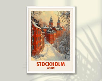 May include: A framed vintage travel poster featuring a winter scene in Stockholm, Sweden. The artwork depicts red buildings and snow-covered trees lining a street leading to a church. The word "STOCKHOLM" is printed in large letters at the bottom.