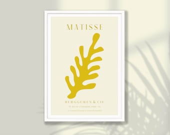 以下が含まれることがあります： 黄色の抽象的な葉のデザインと、上部に「MATISSE」、下部に「BERGGUREN & CIE」というテキストが書かれたミニマルなポスター。ポスターは白い枠で囲まれています。