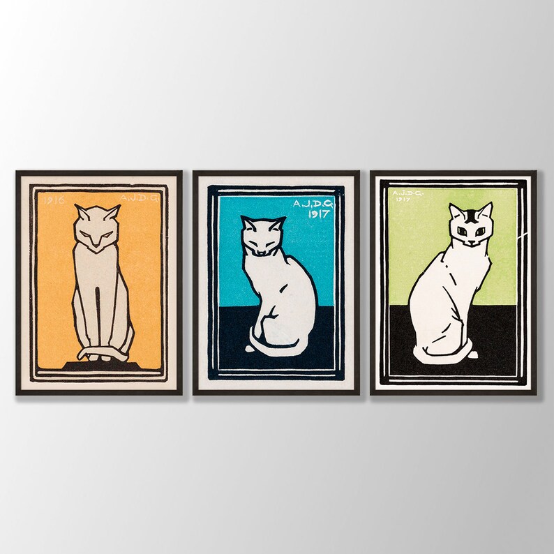 May include: Three framed prints of white cats in different poses. The frames are black and the backgrounds are orange, blue, and green. The prints are dated 1916, 1917, and 1917.