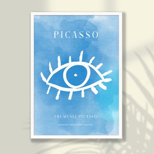 May include: Framed art print featuring a blue watercolor background with a white eye illustration. The word "PICASSO" is at the top, with "THE MUSEU PICASSO" and text below. The artwork is in a white frame.