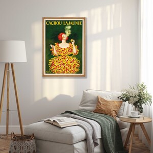 May include: Vintage poster advertising Cachou Lajaunie, a French brand of cough drops. The poster features a woman in a yellow and red dress with a cigarette in her hand and smoke coming from her mouth.