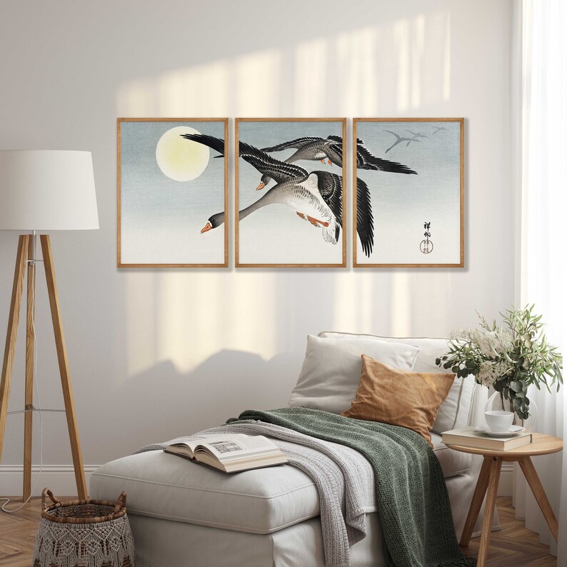 May include: A triptych of framed art prints featuring a flock of geese in flight against a pale blue sky with a full moon. The artwork has a traditional Japanese aesthetic with muted colors and a minimalist style.