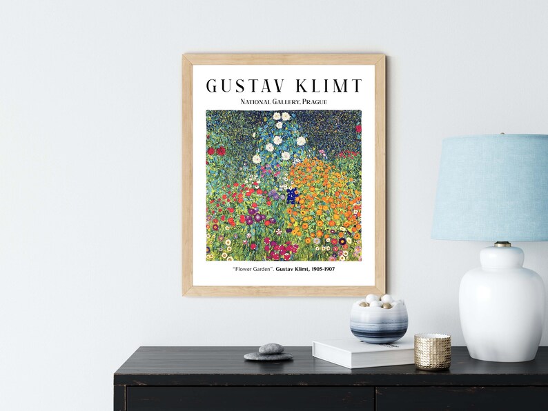 Op de afbeelding: Een ingelijste print van een schilderij van Gustav Klimt getiteld "Bloementuin". Het schilderij toont een levendig veld met bloemen in verschillende kleuren, waaronder rood, geel, oranje, blauw en groen. Het schilderij is ingelijst in een houten lijst met een witte passe-partout.