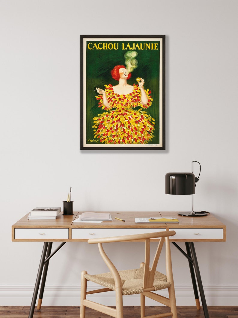 May include: Vintage poster advertising Cachou Lajaunie, a brand of breath mints. The poster features a woman in a yellow and red dress smoking a cigarette. The text "CACHOU LAJAUNIE" is printed in black at the top of the poster.