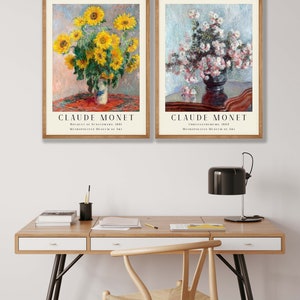 May include: Two framed art prints of paintings by Claude Monet. The left print shows a bouquet of sunflowers in a vase on a table with a red tablecloth. The right print shows a bouquet of pink chrysanthemums in a vase on a table with a brown tablecloth. Both prints include the title of the painting and the museum where it is located.