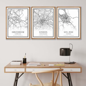 Puede incluir: Tres l&aacute;minas decorativas enmarcadas con mapas urbanos en blanco y negro de &Aacute;msterdam, Londres y San Jos&eacute;. Cada impresi&oacute;n incluye el nombre de la ciudad, el pa&iacute;s o estado y las coordenadas geogr&aacute;ficas en una tipograf&iacute;a negra sobre papel blanco.