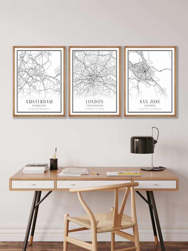Puede incluir: Tres l&aacute;minas decorativas enmarcadas con mapas urbanos en blanco y negro de &Aacute;msterdam, Londres y San Jos&eacute;. Cada impresi&oacute;n incluye el nombre de la ciudad, el pa&iacute;s o estado y las coordenadas geogr&aacute;ficas en una tipograf&iacute;a negra sobre papel blanco.