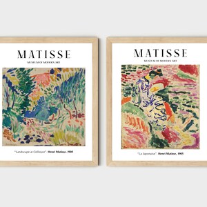 May include: Two framed art prints of paintings by Henri Matisse. The first print is titled "Landscape at Collioure" and depicts a colorful landscape with trees and hills. The second print is titled "La Japonaise" and features a woman in a colorful dress standing in a landscape.