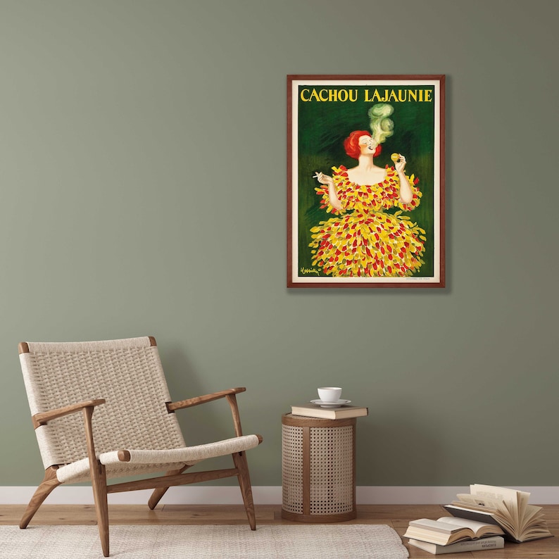 May include: A vintage poster advertising Cachou Lajaunie, a brand of cough drops. The poster features a woman in a yellow and red dress, smoking a cigarette and holding a box of Cachou Lajaunie.