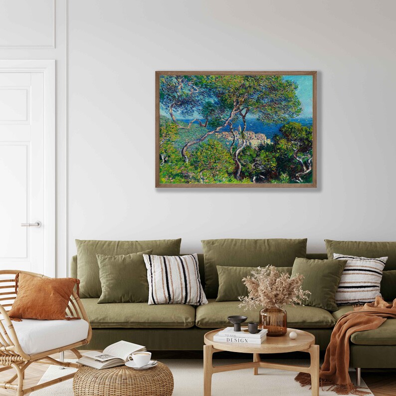 May include: A framed painting of a landscape scene with a view of a town from a hilltop. The painting features a bright blue sky, green trees, and a small town in the distance. The painting is framed in a simple wooden frame.