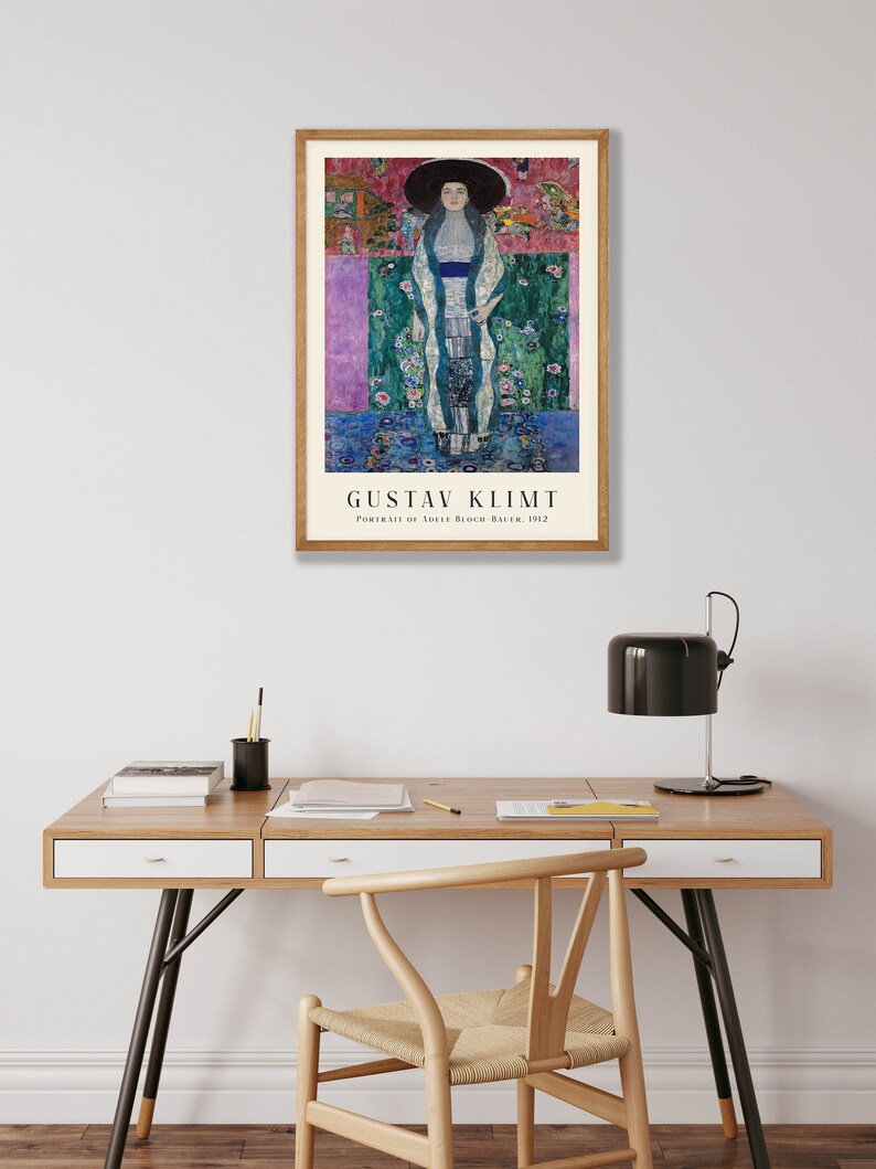 Pu&ograve; includere: Un poster incorniciato di un dipinto di Gustav Klimt intitolato "Ritratto di Adele Bloch-Bauer, 1907". Il dipinto raffigura una donna con un lungo abito fluido con un motivo floreale. Lo sfondo &egrave; un mix vibrante di colori e motivi.