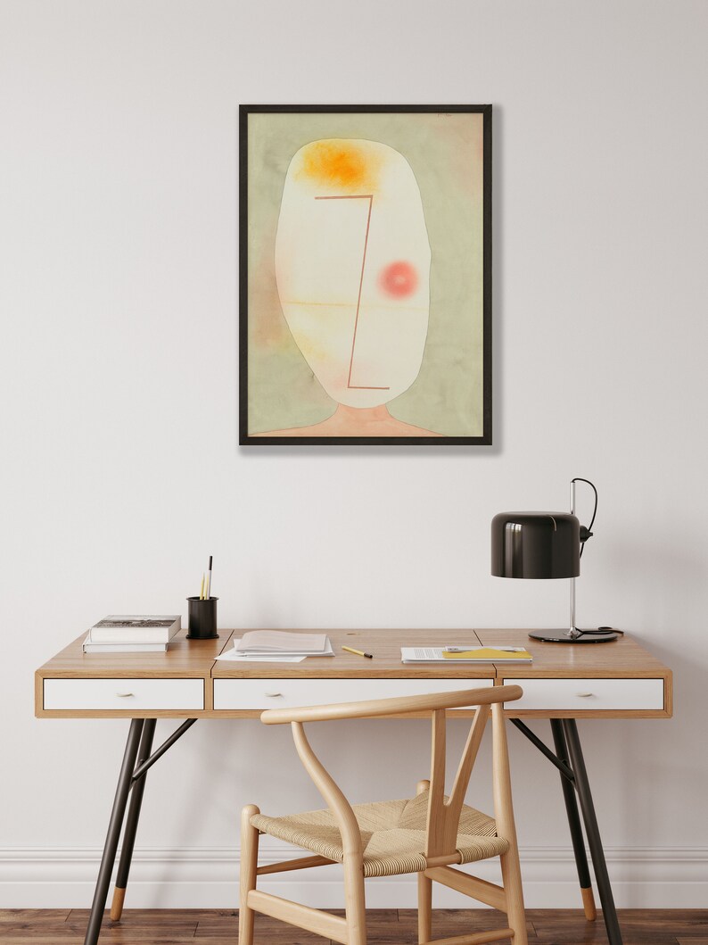 May include: A framed abstract wall art print featuring a pale, oval-shaped head against a muted sage green background. The artwork includes a bright yellow patch at the top, a soft red circle on the right, and a thin, dark red geometric line.