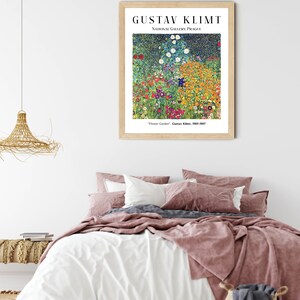 Op de afbeelding: Een ingelijste print van een schilderij van Gustav Klimt getiteld "Bloementuin". Het schilderij toont een levendig veld met bloemen in verschillende kleuren, waaronder rood, geel, oranje, blauw en wit. Het schilderij is tentoongesteld in een houten lijst met een witte passe-partout.