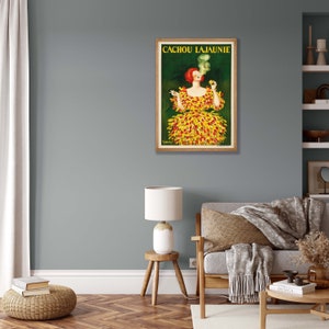 May include: Vintage poster advertising Cachou Lajaunie, a French brand of cough drops. The poster features a woman in a yellow and red dress smoking a cigarette.