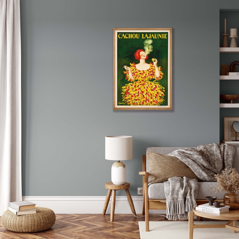 May include: Vintage poster advertising Cachou Lajaunie, a French brand of cough drops. The poster features a woman in a yellow and red dress smoking a cigarette.