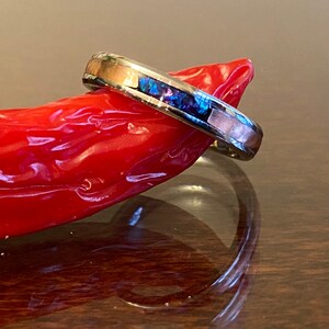 May include: A silver band ring with a thin inlay of abalone shell and a copper band.