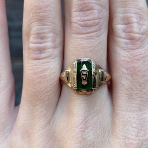 May include: A gold class ring with a green stone and the letters "PA" on the side.