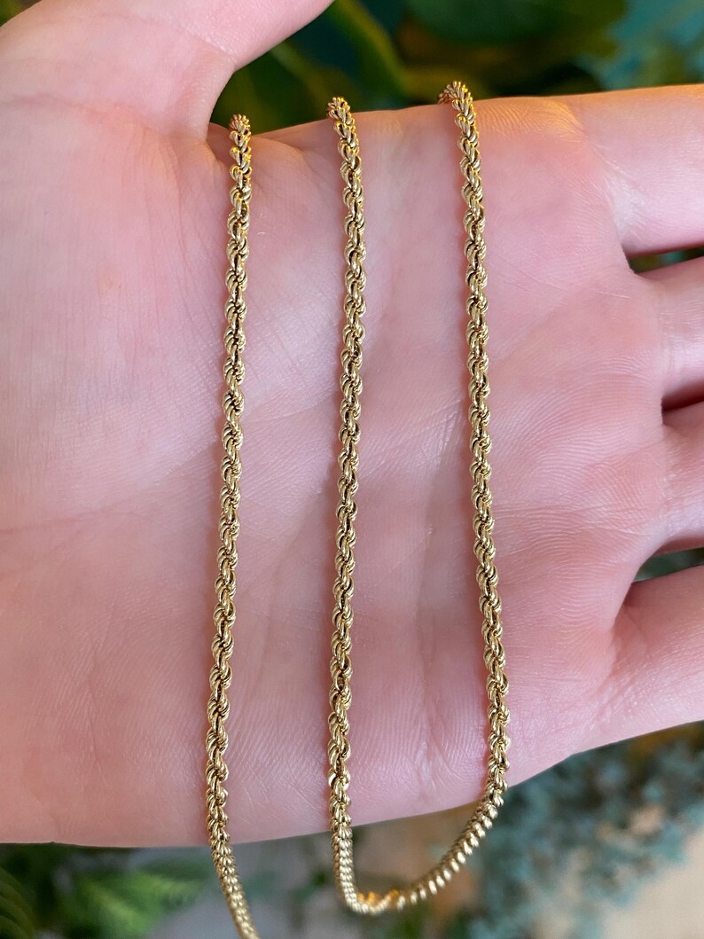 Puede incluir: Primer plano de tres cadenas de cuerda doradas. Las cadenas est&aacute;n hechas de eslabones retorcidos, creando una superficie texturizada. Las cadenas se muestran sobre un fondo neutro, resaltando su color y dise&ntilde;o. Las cadenas son probablemente joyas.