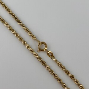 Puede incluir: Un collar de cadena de cuerda de color dorado con un cierre de anillo de resorte. La cadena est&aacute; hecha de eslabones retorcidos, creando una textura similar a la de una cuerda. El cierre es de dise&ntilde;o simple y seguro.