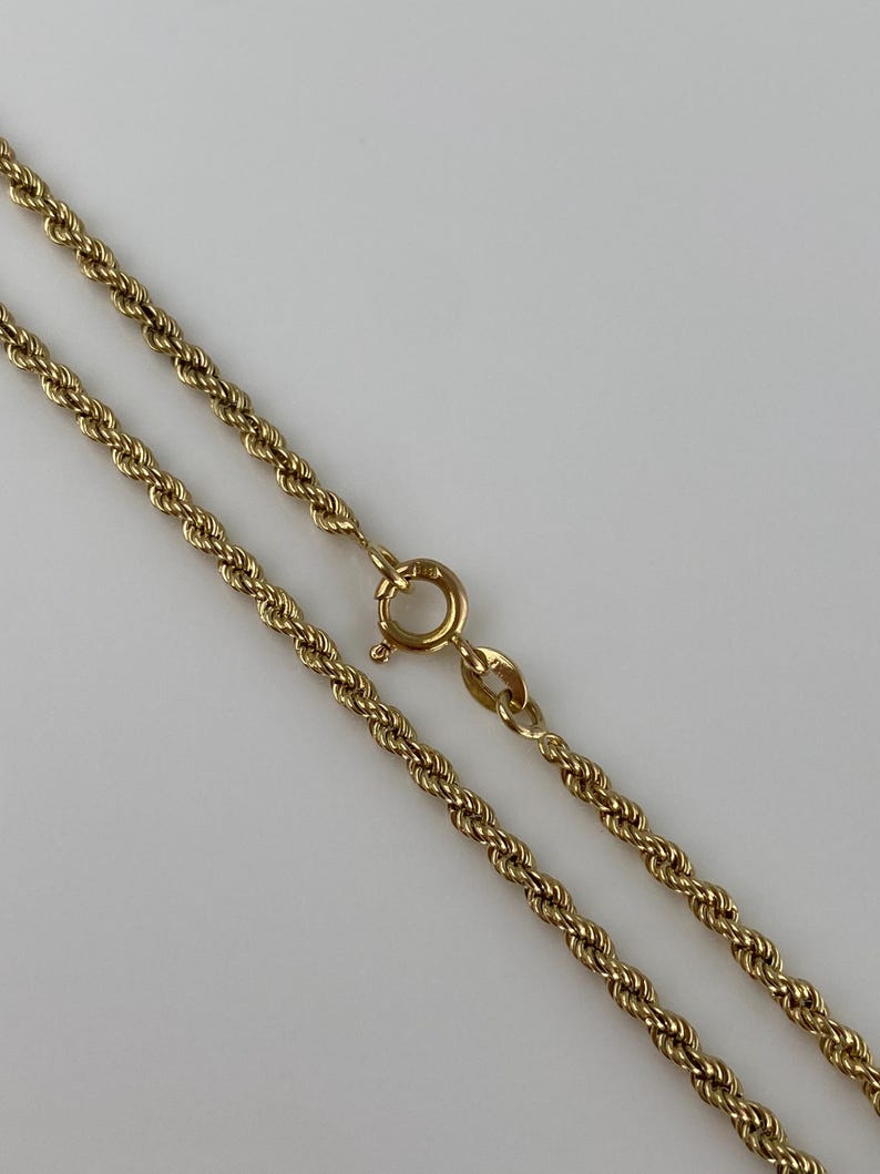 Puede incluir: Un collar de cadena de cuerda de color dorado con un cierre de anillo de resorte. La cadena est&aacute; hecha de eslabones retorcidos, creando una textura similar a la de una cuerda. El cierre es de dise&ntilde;o simple y seguro.