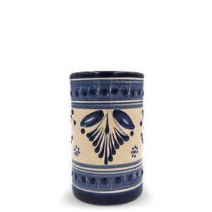 May include: A cylindrical ceramic container with a cream-colored center and blue decorative patterns. The blue designs include floral motifs, dots, and bands. The container has a dark blue rim and base, and is likely used for storage or display.
