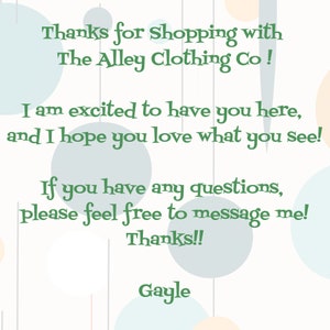 May include: A green text message on a white background with pastel blue and peach circles. The text reads: "Thanks for shopping with The Alley Clothing Co! I am excited to have you here, and I hope you love what you see! If you have any questions, please feel free to message me! Thanks!! Gayle"