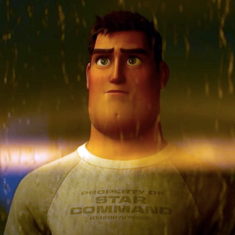 May include: A man with a serious expression looks up at the rain. He is wearing a grey sweatshirt with the text "PROPERTY OF STAR COMMAND 1012007875000" printed on the front.