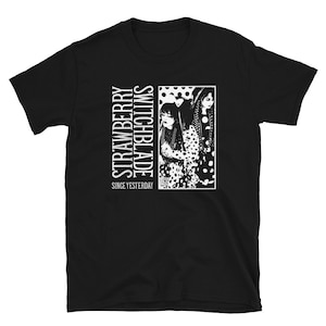 Puede incluir: Camiseta negra con un gráfico blanco de dos mujeres con vestidos de lunares. El texto "Strawberry Switchblade" y "Since Yesterday" está impreso en la camiseta.
