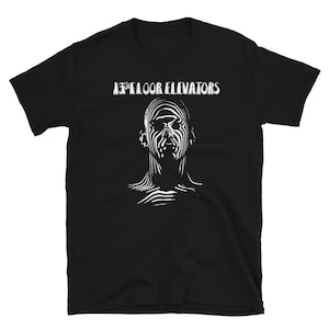 May include: Black t-shirt with a white graphic of a face and the text "13th Floor Elevators".