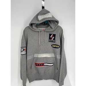 Könnte beinhalten: Grauer Perry Ellis Hoodie mit Kapuze mit Kordelzug und Kängurutasche. Der Hoodie hat mehrere Aufnäher mit dem Perry Ellis-Logo und den Worten "America Perry Ellis". Ein reflektierender silberner Streifen akzentuiert die Brust.