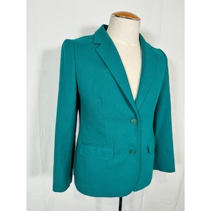 May include: A teal blazer with a single-breasted closure and two button pockets. The blazer has a classic, tailored fit.