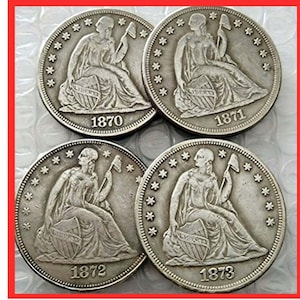 Puede incluir: Cuatro monedas de plata de dólar comercial estadounidense de 1870, 1871, 1872 y 1873. Las monedas presentan una figura de la Libertad sentada sosteniendo una antorcha y una rama de olivo.