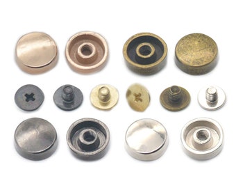 May include: Assortment of metal rivets in various finishes, including gold, silver, brass, and black. The rivets have a domed head and a threaded shank for attaching to fabric or leather.