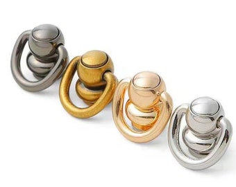 May include: Four spinning metal rings with a ball in the center. The rings are in different colors: silver, gold, rose gold, and black.