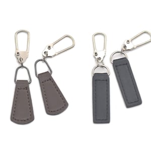 May include: Two sets of zipper pulls with leather tabs. One set is brown and the other is black.