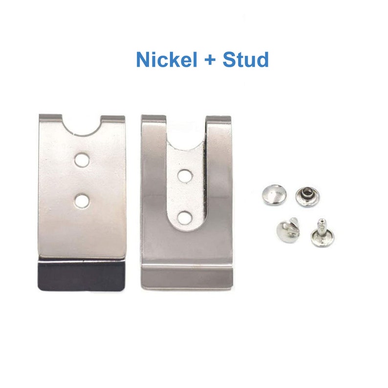 Puede incluir: Dos clips de cintur&oacute;n de metal niquelado con respaldo de goma negra. Los clips est&aacute;n dise&ntilde;ados para sujetarse a un cintur&oacute;n o cintura. La imagen tambi&eacute;n muestra cuatro remaches de metal plateados.