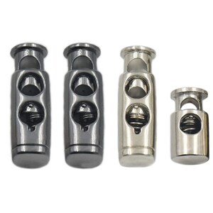 May include: Four toggle cord locks in two finishes: black and silver. The cord locks have a spring mechanism and two holes for threading cord.