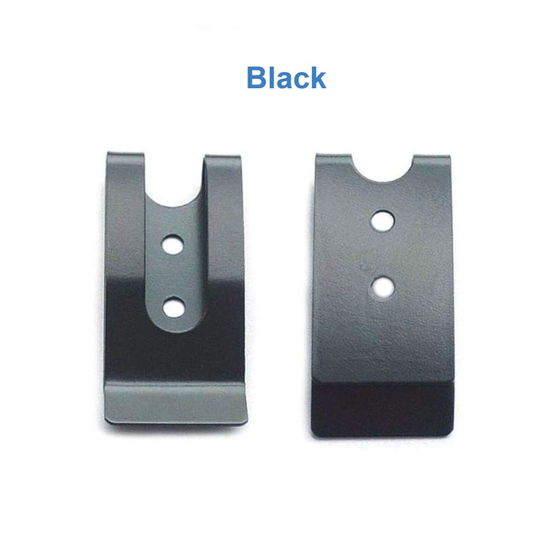 Puede incluir: Dos clips de cintur&oacute;n de metal negro. El clip de la izquierda tiene una parte superior curva y tres agujeros. El clip de la derecha tiene una parte superior recta y dos agujeros.