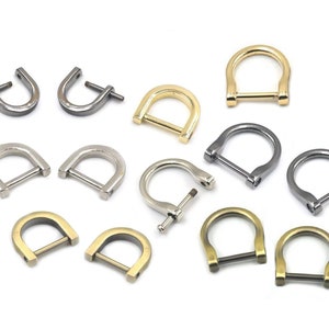 May include: Assortment of metal D-rings in various finishes, including silver, gold, and black. The D-rings are all the same size and have a smooth, polished finish.