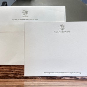 May include: A white envelope and a white note card with the Earthworks logo, which is a stylized tree inside a circle. The text on the envelope reads "EARTHWORKS 1612 K St. NW, Suite 904 Washington, DC 20006". The text on the note card reads "A note from Earthworks Protecting Communities and the Environment | Earthworks.org".