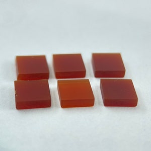 Peut inclure: Six petits carreaux de verre carrés, translucides et de couleur ambre.
