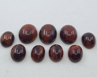 May include: Ten red tiger's eye cabochons in various sizes and shapes. The stones are smooth and polished, with a reddish-brown color and a subtle sheen.