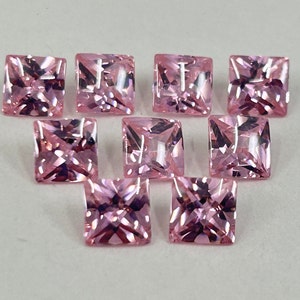 May include: Ten pink square-shaped gemstones with a faceted cut.