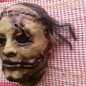 May include: A realistic horror mask with stitched-up wounds and a sewn-shut mouth. The mask is made of latex and has a realistic skin tone. It is designed to be worn for Halloween or other fancy dress events.
