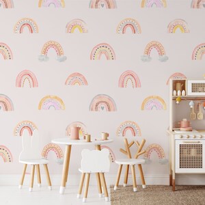 Puede incluir: Una habitaci&oacute;n de beb&eacute; rosa con una cocina de juguete y una mesa y sillas. Las paredes est&aacute;n decoradas con un patr&oacute;n de arco&iacute;ris.